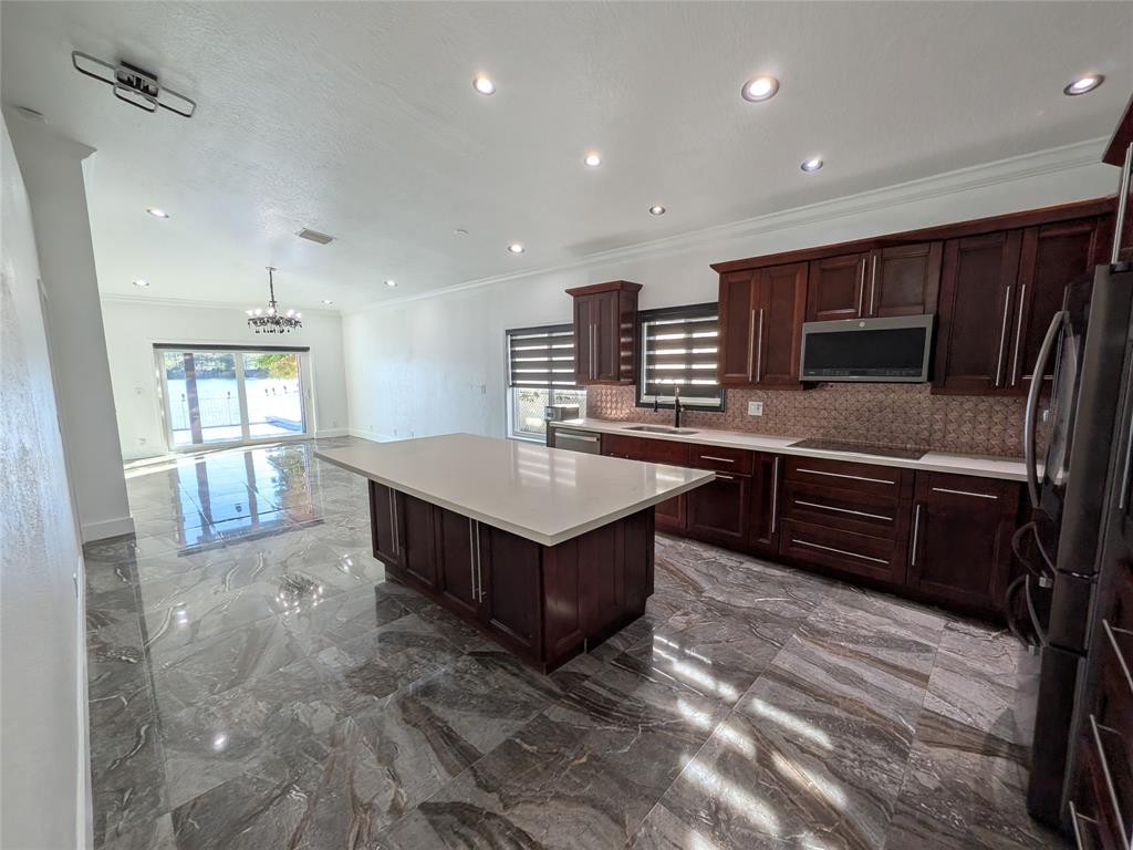 4572 Southwest 14th Street Deerfield Beach, FL 33442 - Photo 10 of 58 a kitchen with a refrigerator and a stove top oven