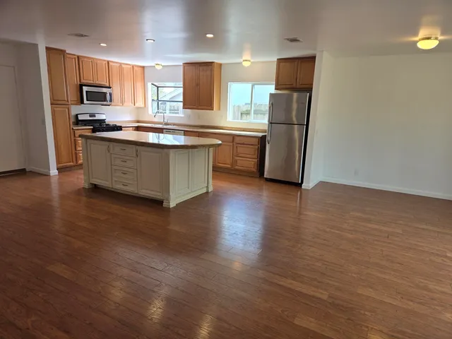 a kitchen with stainless steel appliances a refrigerator and a stove top oven