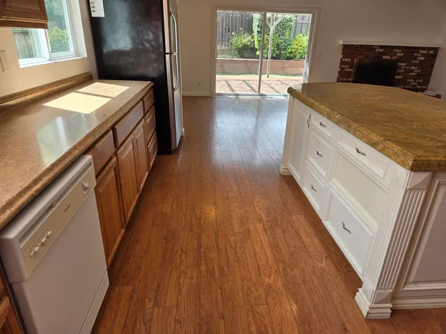 a view of a kitchen with wooden floor and electronic appliances