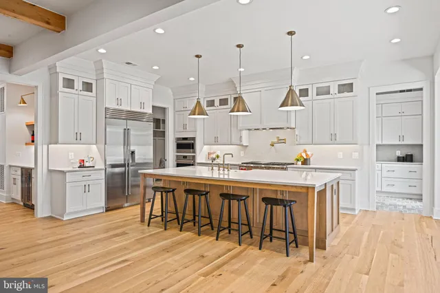a kitchen with kitchen island a counter top space appliances and cabinets