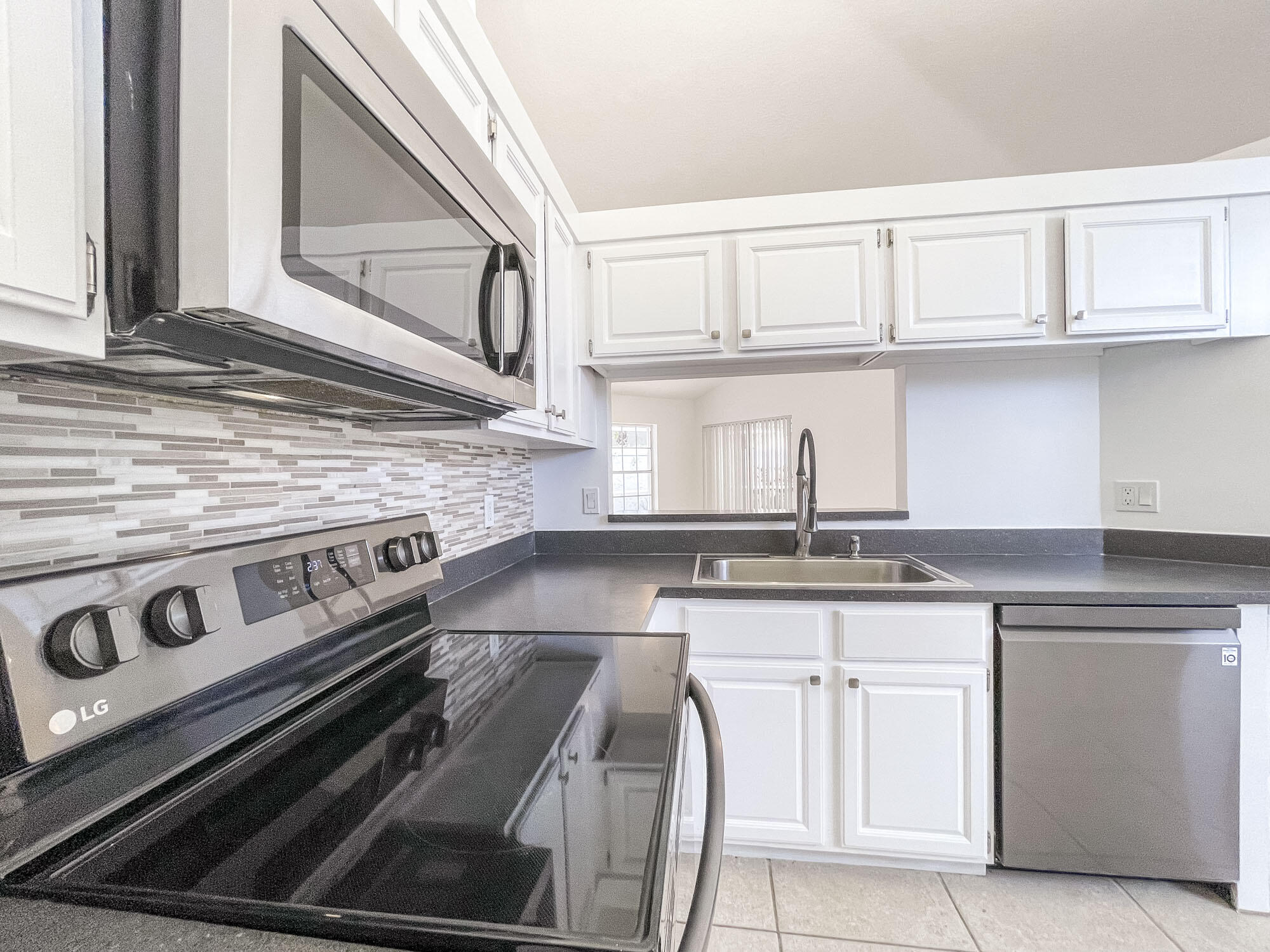 252 Moccasin Trail West Jupiter, FL 33458 - Photo 11 of 24 a kitchen with granite countertop a stove sink and cabinets