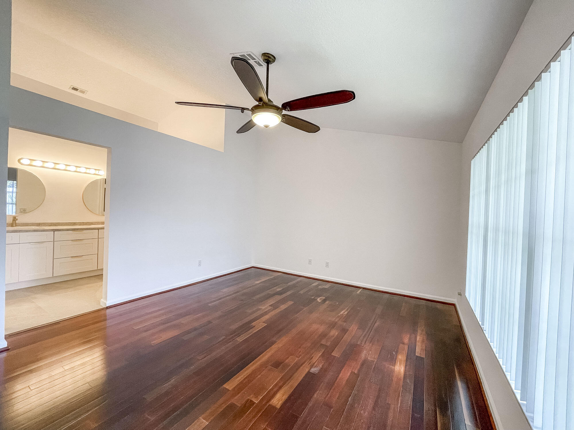 252 Moccasin Trail West Jupiter, FL 33458 - Photo 13 of 24 an empty room with wooden floor fan and windows
