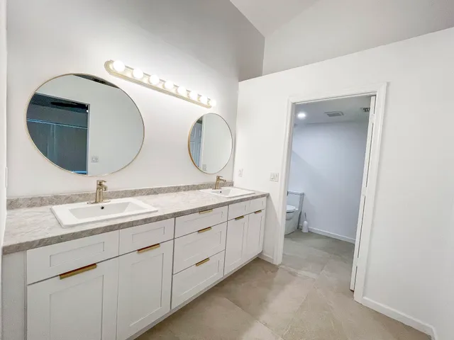a bathroom with a double vanity sink and a mirror