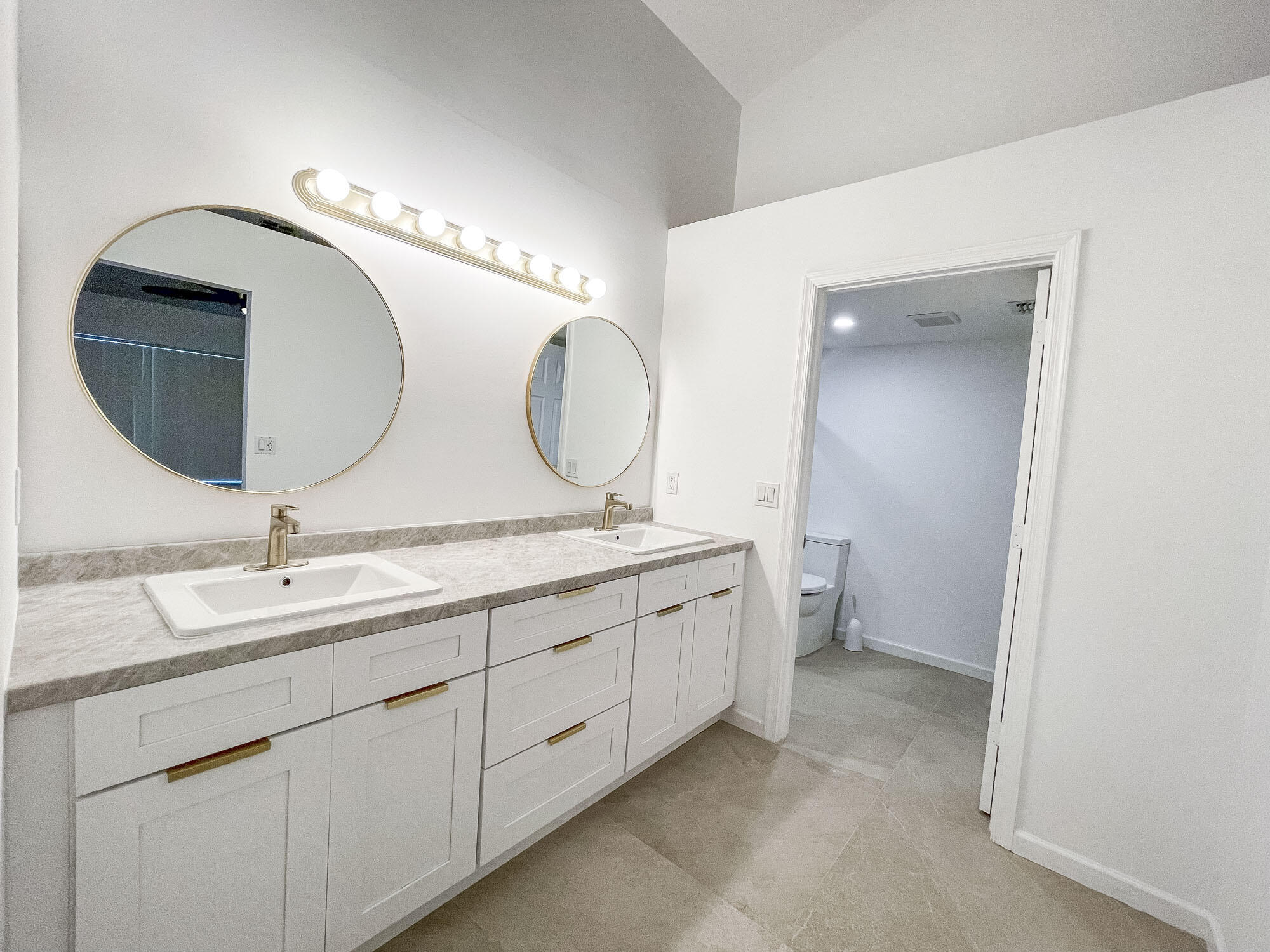 252 Moccasin Trail West Jupiter, FL 33458 - Photo 14 of 24 a bathroom with a double vanity sink and a mirror