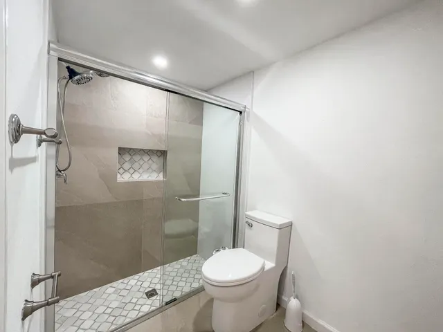 a bathroom with a toilet and a shower