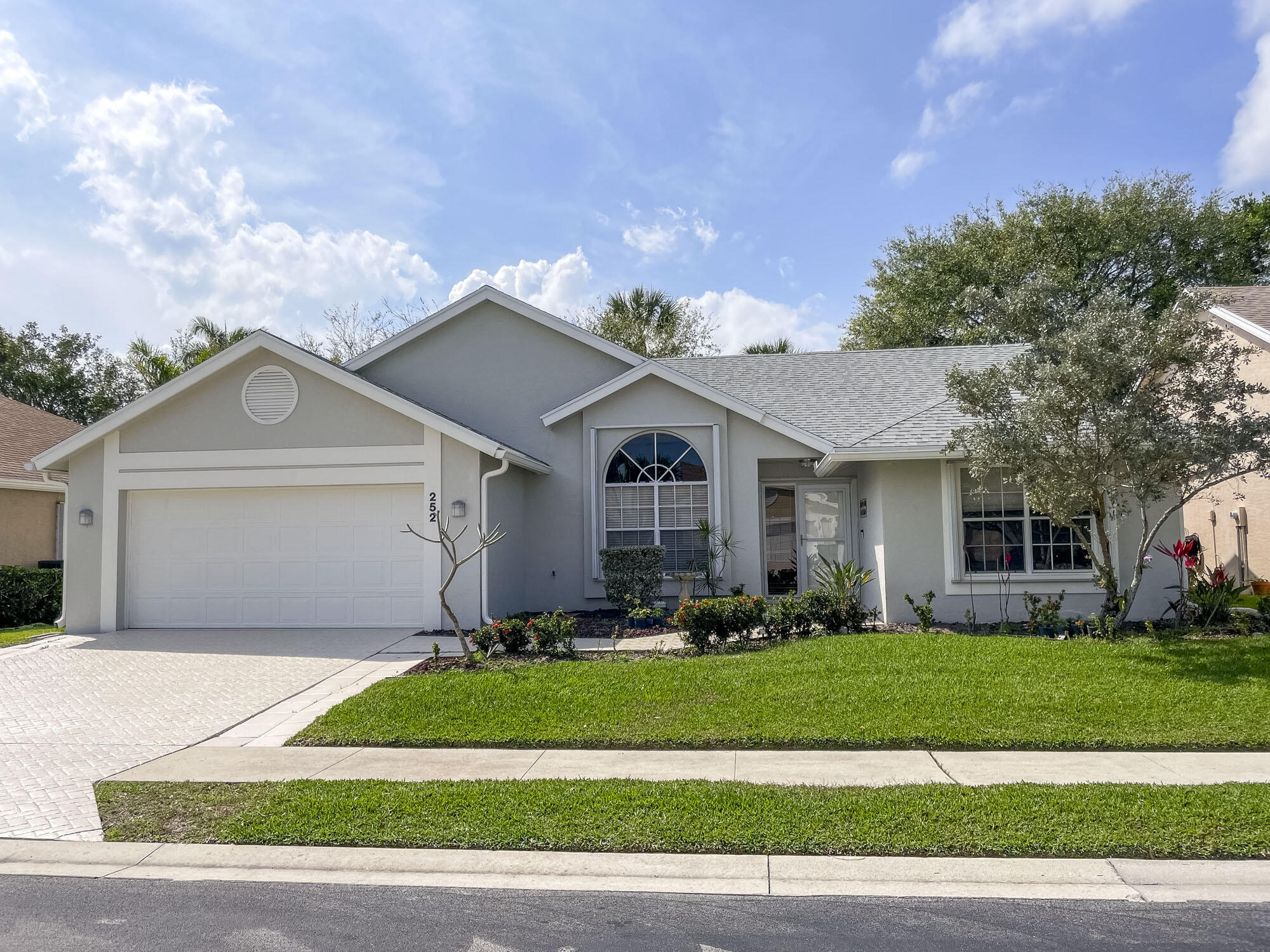 252 Moccasin Trail West Jupiter, FL 33458 - Photo 2 of 24 a front view of a house with a yard and garage