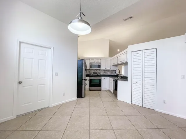 a kitchen with granite countertop a stove a sink and a refrigerator