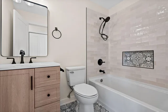 a bathroom with a granite countertop toilet sink and a bathtub