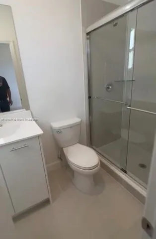 a white toilet sitting next to a shower