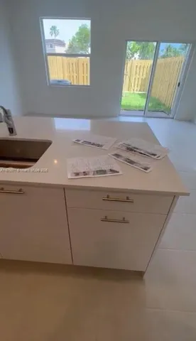 a room with a sink cabinets and a window
