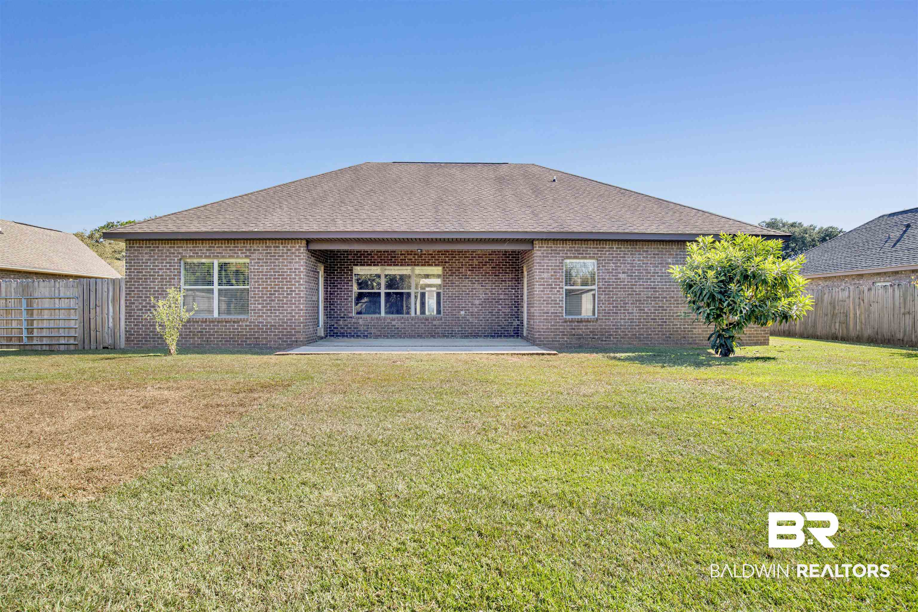 24159 Tullamore Drive Daphne, AL 36526 - Photo 31 of 31 Back of house with a patio and a lawn
