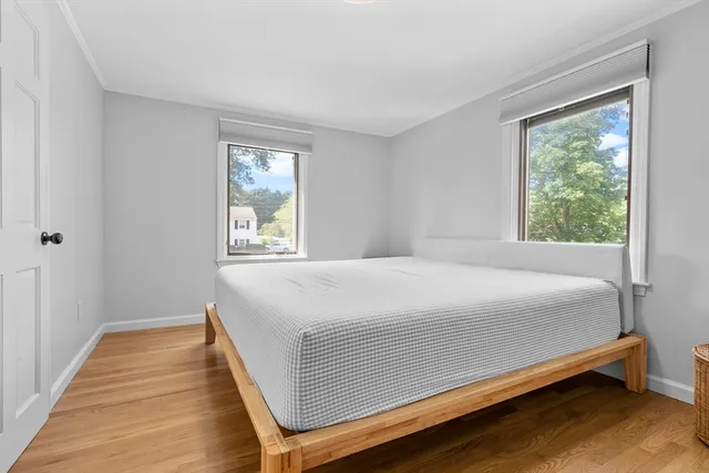 a large bed sitting in a bedroom next to a window