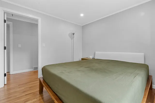 a bedroom with a bed and wooden floor