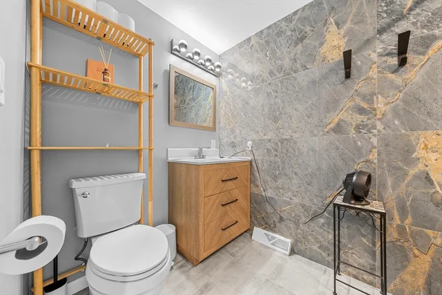 a bathroom with a toilet a sink and mirror