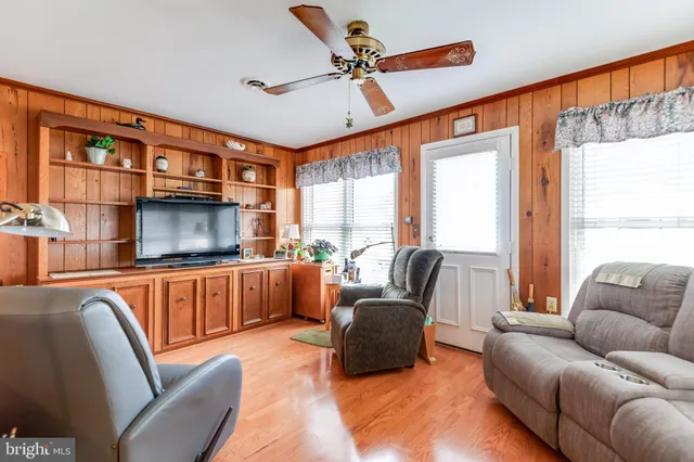 a living room with furniture a ceiling fan and a window