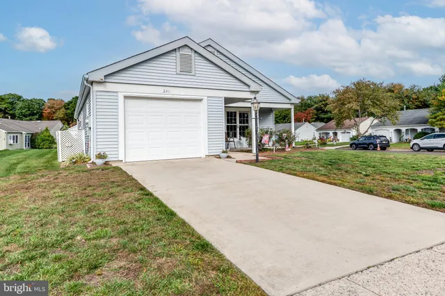 a front view of a house with a garden and trees