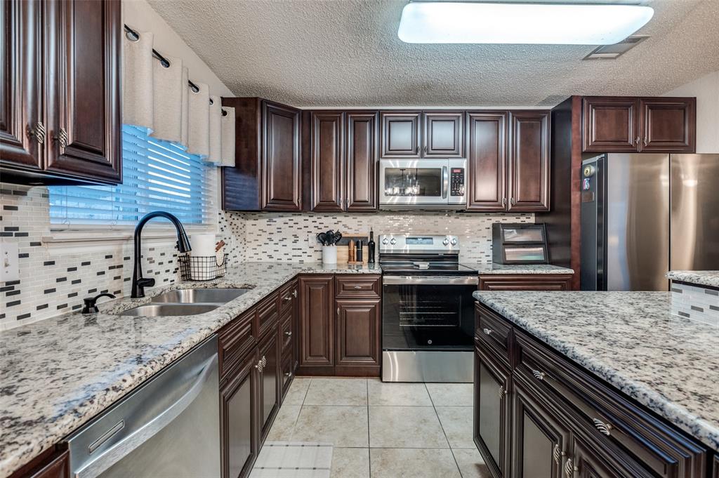 656 Condor Trail Saginaw, TX 76131 - Photo 11 of 25 a large kitchen with granite countertop stainless steel appliances and a sink