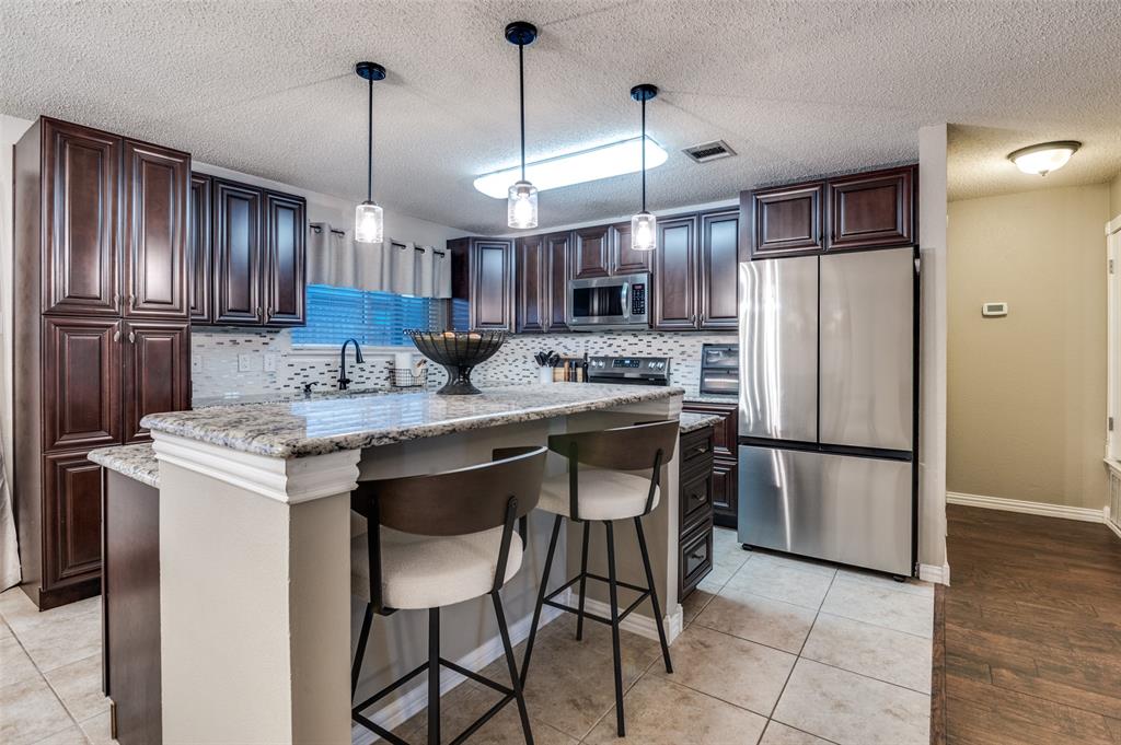 656 Condor Trail Saginaw, TX 76131 - Photo 12 of 25 a kitchen with stainless steel appliances granite countertop a sink a stove a refrigerator and island