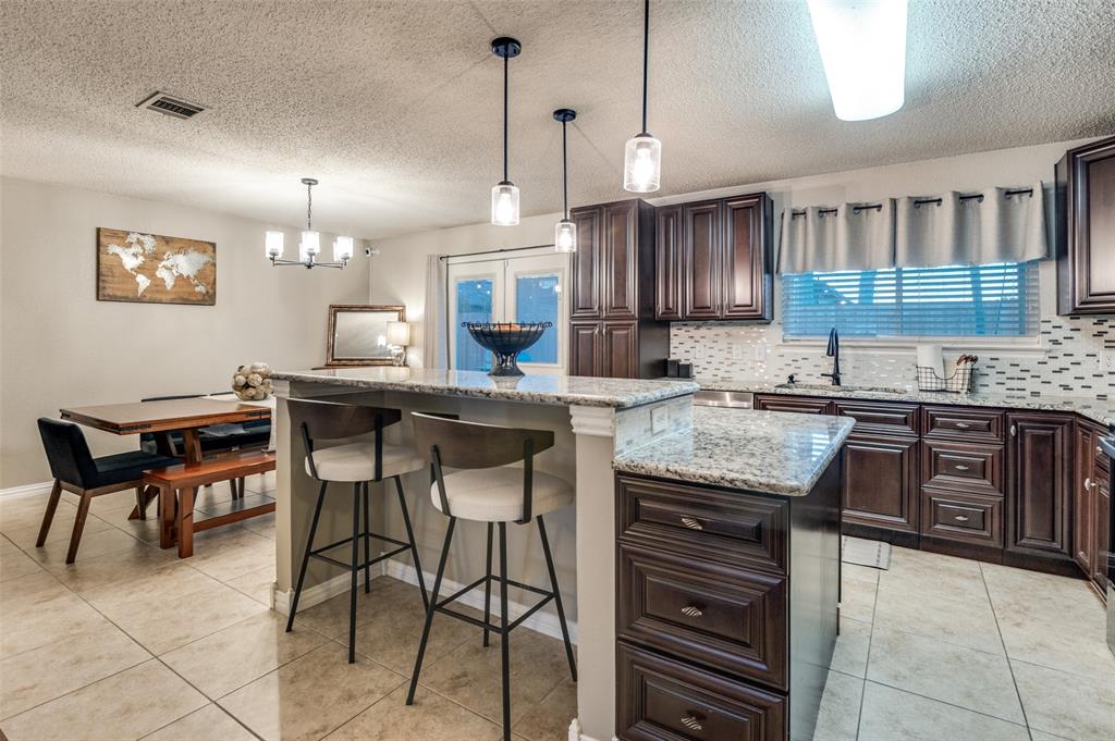 656 Condor Trail Saginaw, TX 76131 - Photo 8 of 25 a kitchen with granite countertop a sink counter and chairs