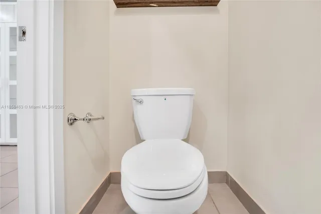 a white toilet sitting next to a white wall