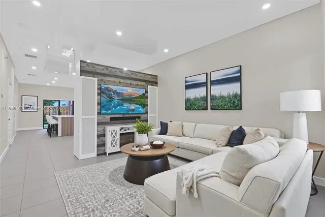 a living room with furniture a rug and a flat screen tv