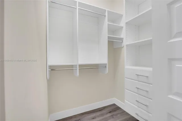 a view of walk in closet with empty racks