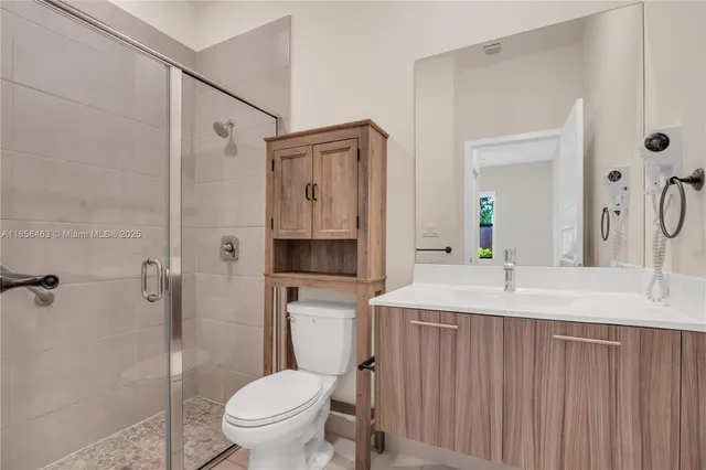 a bathroom with a granite countertop sink toilet and shower