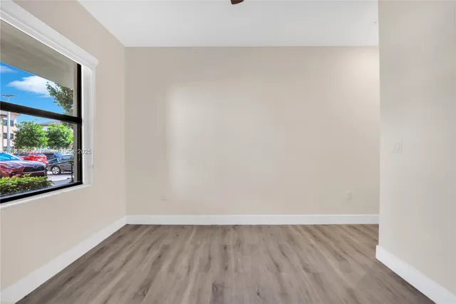 a view of a room with wooden floor and window