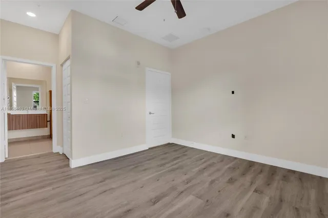 wooden floor in an empty room with a kitchen