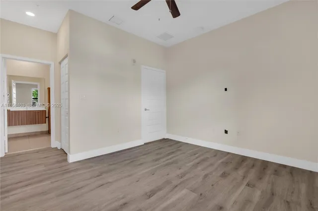 wooden floor in an empty room with a kitchen