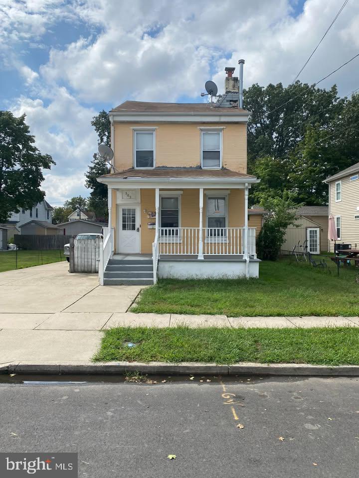 509 Laurel Street Beverly, NJ 08010 - Photo 1 of 47 a front view of a house with a garden and trees