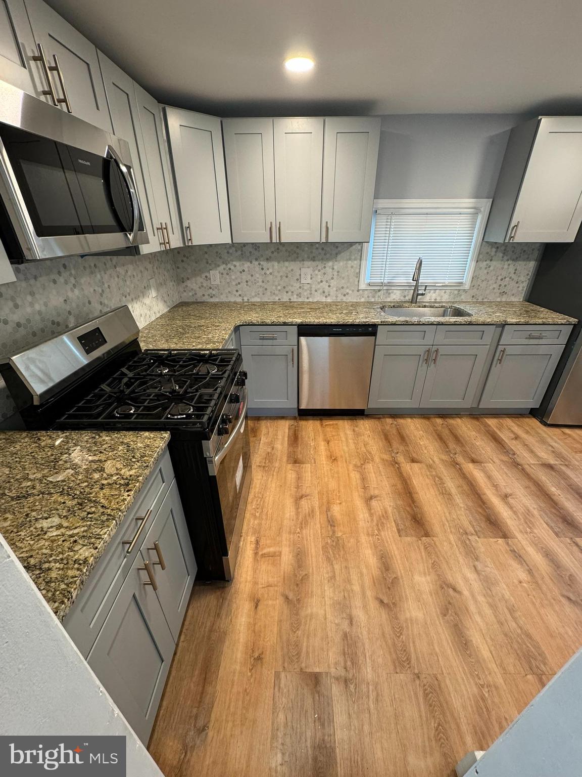 509 Laurel Street Beverly, NJ 08010 - Photo 29 of 47 a kitchen with granite countertop a sink stove and cabinets