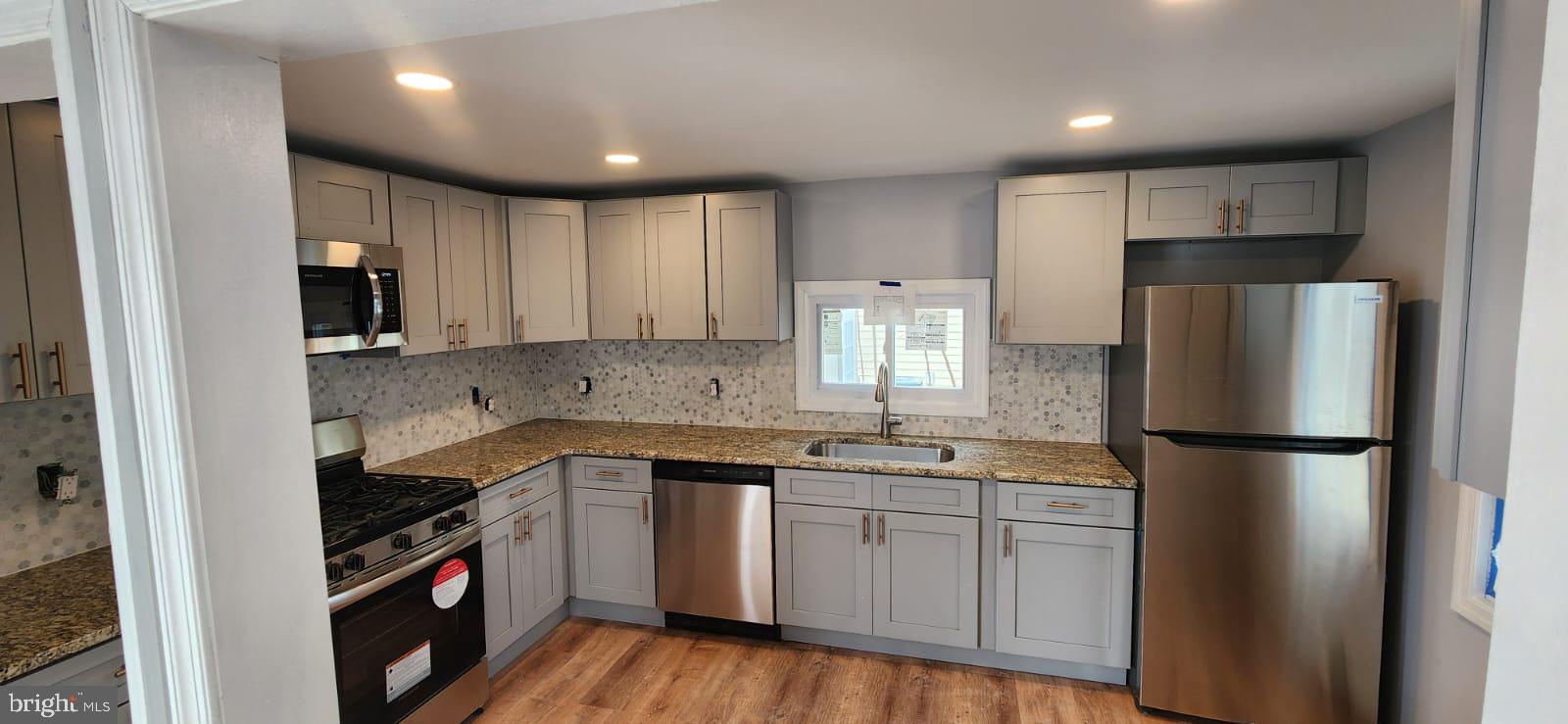 509 Laurel Street Beverly, NJ 08010 - Photo 3 of 47 a kitchen with a sink a refrigerator a microwave and cabinets