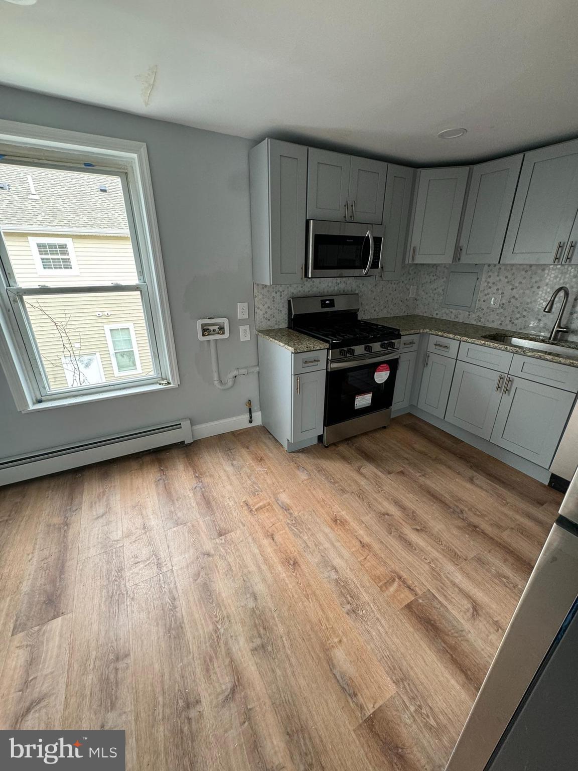 509 Laurel Street Beverly, NJ 08010 - Photo 46 of 47 a kitchen with granite countertop a stove a sink and a microwave