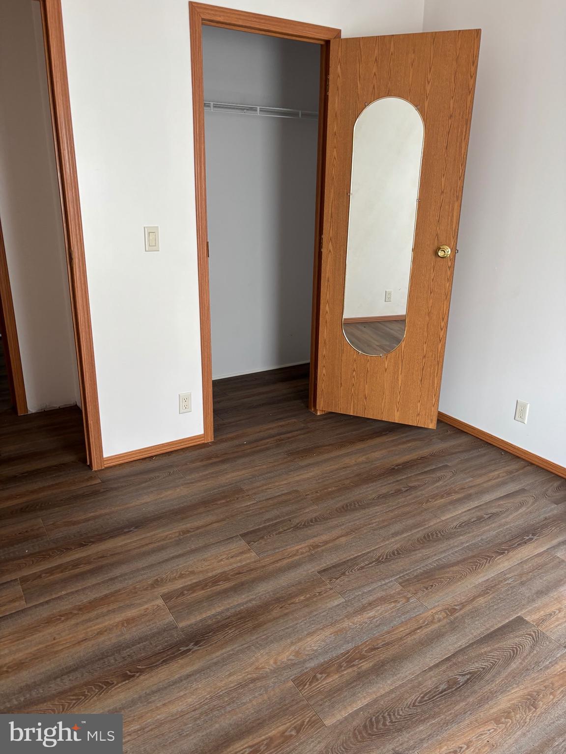 3825 Dickenson Mountain Road Franklin, WV 26807 - Photo 17 of 32 an empty room with wooden floor and mirror