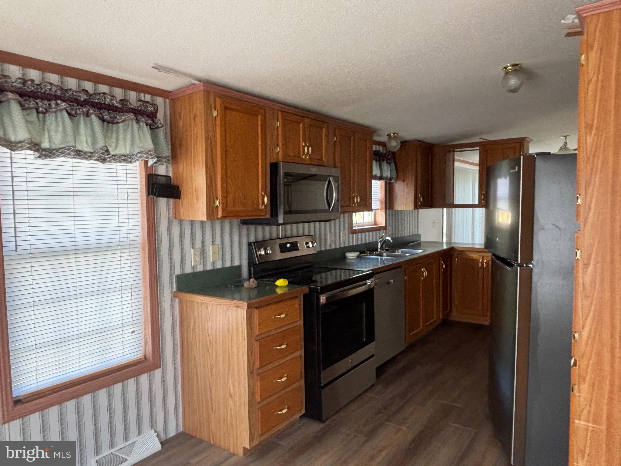 3825 Dickenson Mountain Road Franklin, WV 26807 - Photo 6 of 32 a kitchen with granite countertop a refrigerator stove and microwave
