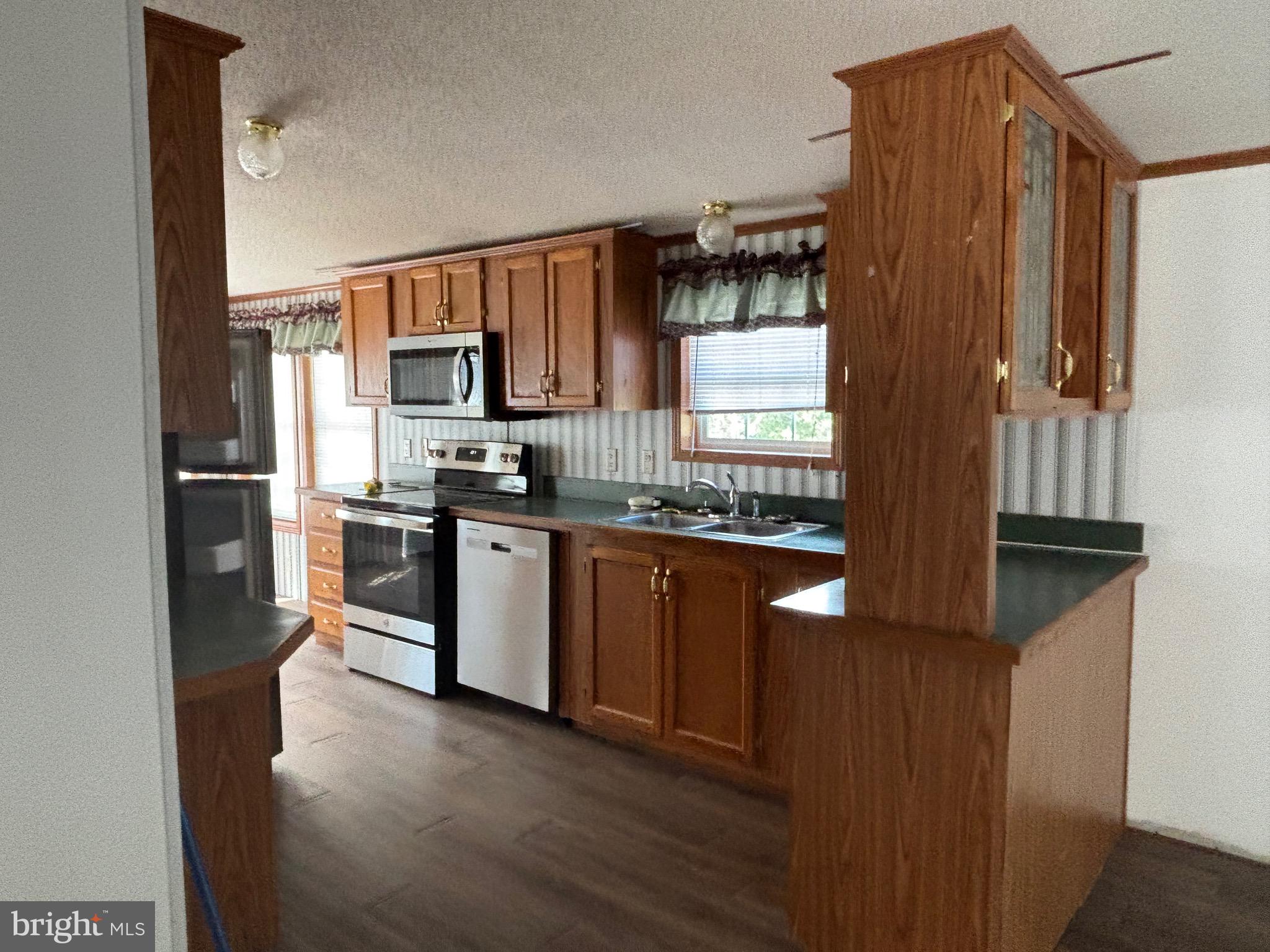3825 Dickenson Mountain Road Franklin, WV 26807 - Photo 8 of 32 a kitchen with stainless steel appliances granite countertop a refrigerator a sink dishwasher a stove and a microwave oven