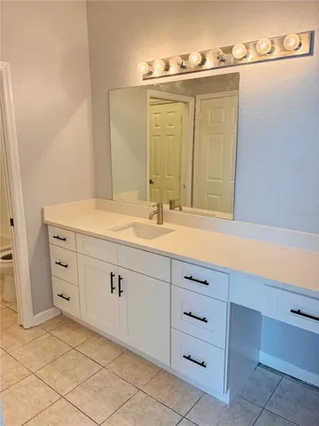 a bathroom with a sink vanity and mirror