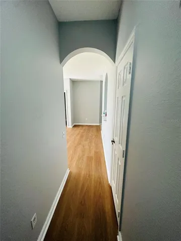 a view of a hallway with wooden floor and staircase