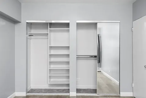 a view of walk in closet with empty racks
