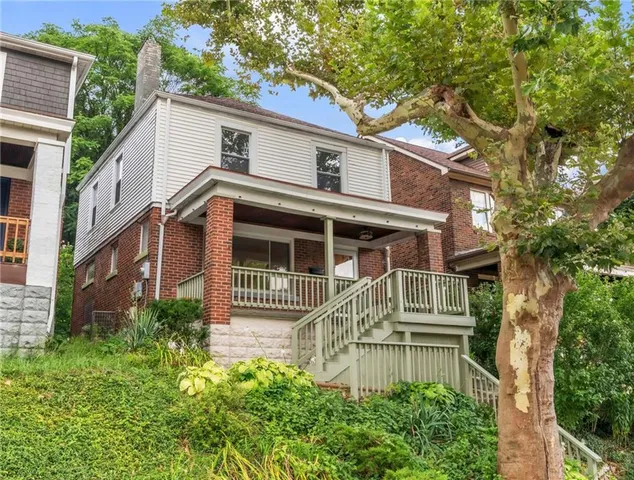 a front view of a house with a garden