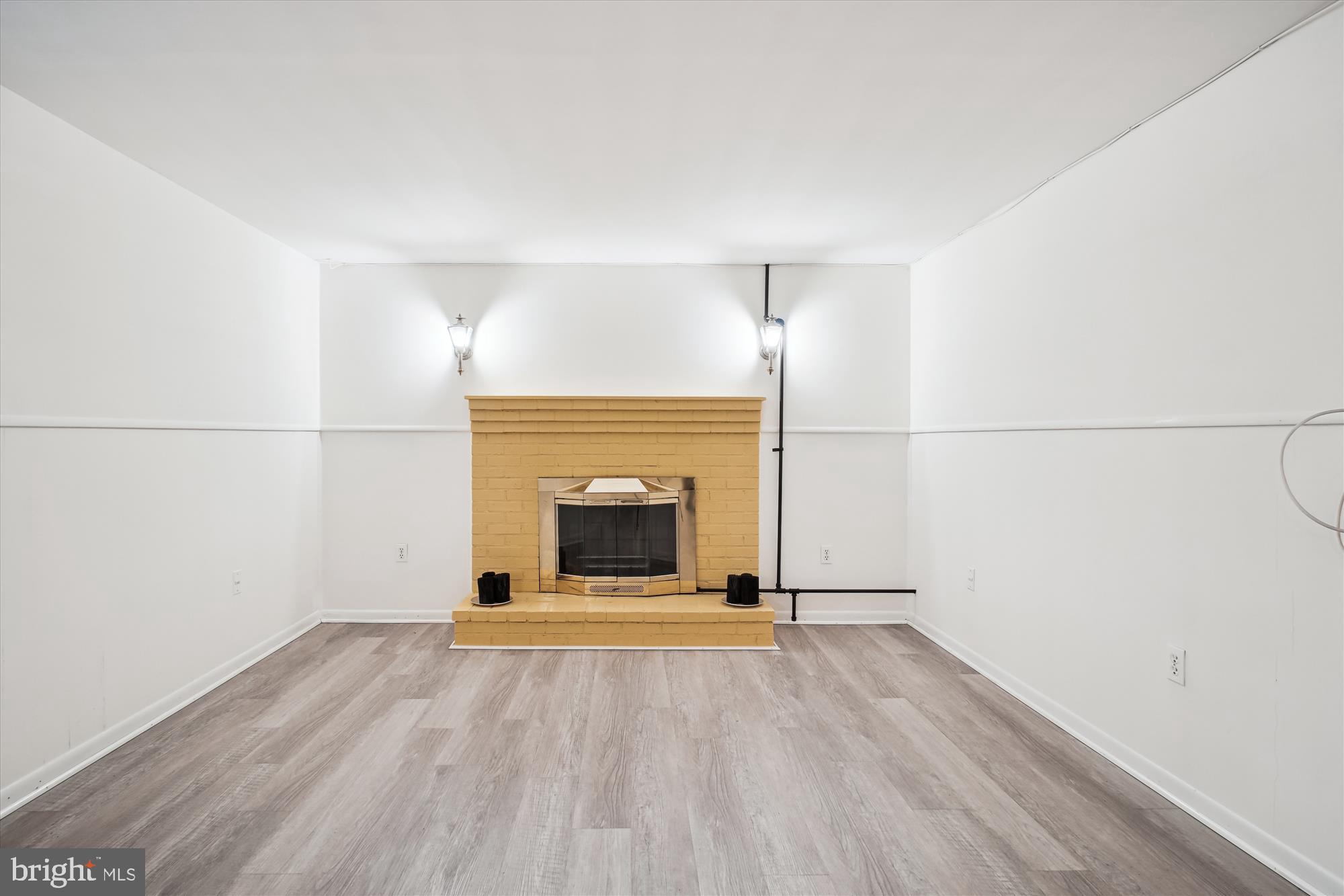 10607 Judicial Drive Fairfax, VA 22030 - Photo 54 of 60 an empty room with wooden floor and fireplace