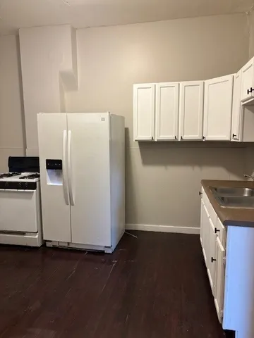 a kitchen with granite countertop white cabinets and white appliances