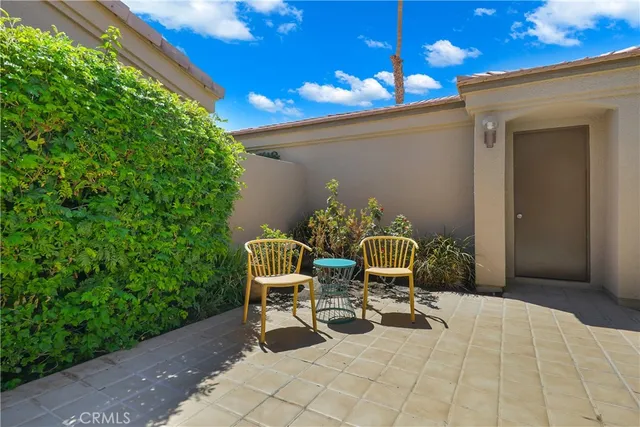 a view of a chair and table in backyard of the house