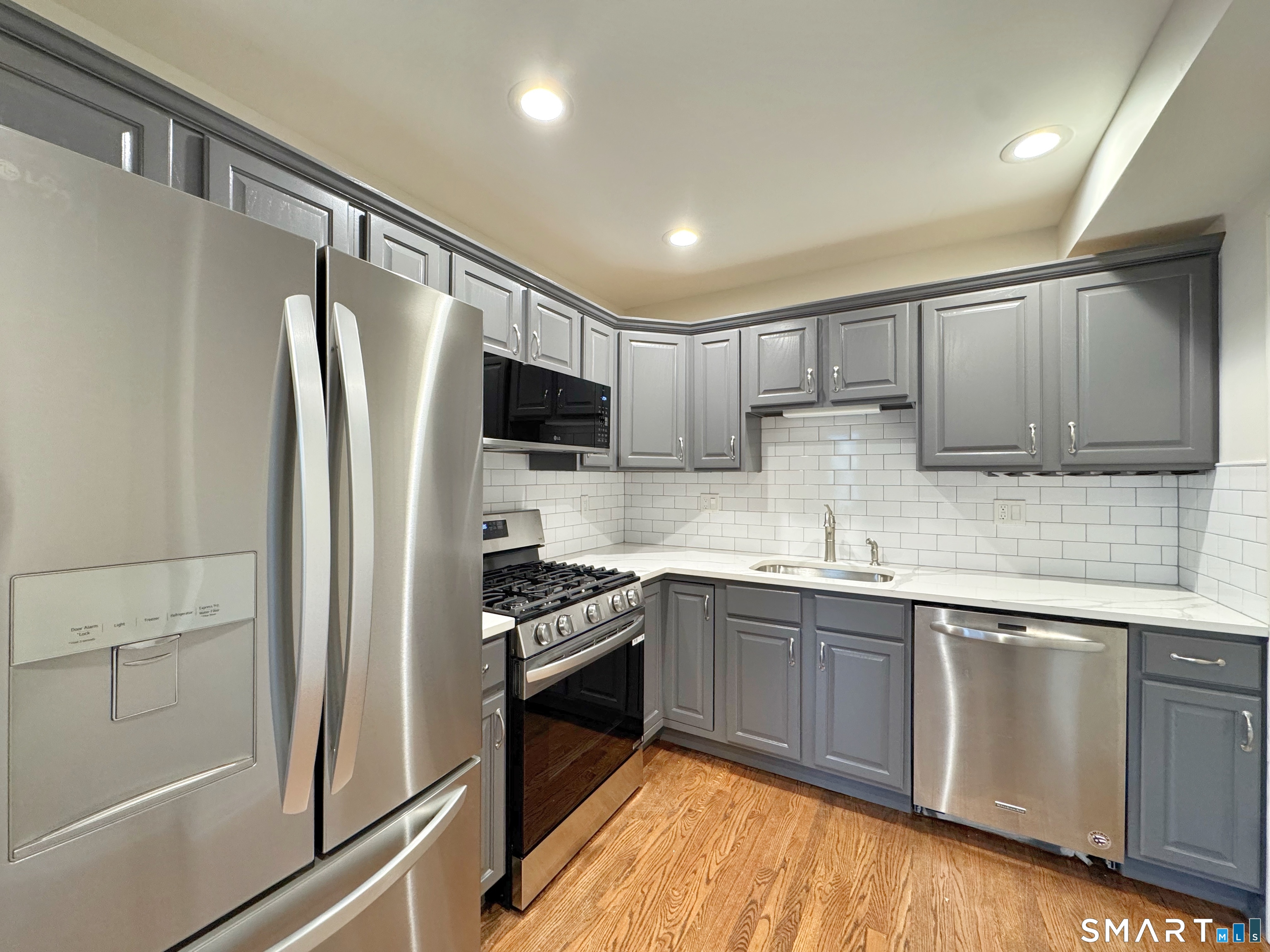 a kitchen with stainless steel appliances granite countertop a refrigerator stove and sink