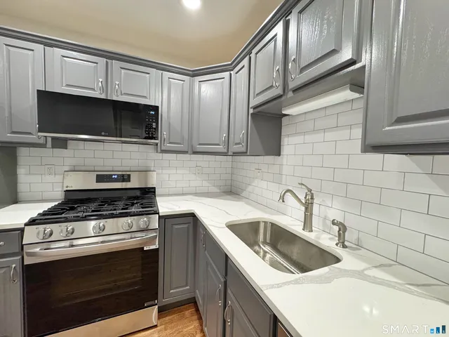 a kitchen with cabinets stainless steel appliances and a sink