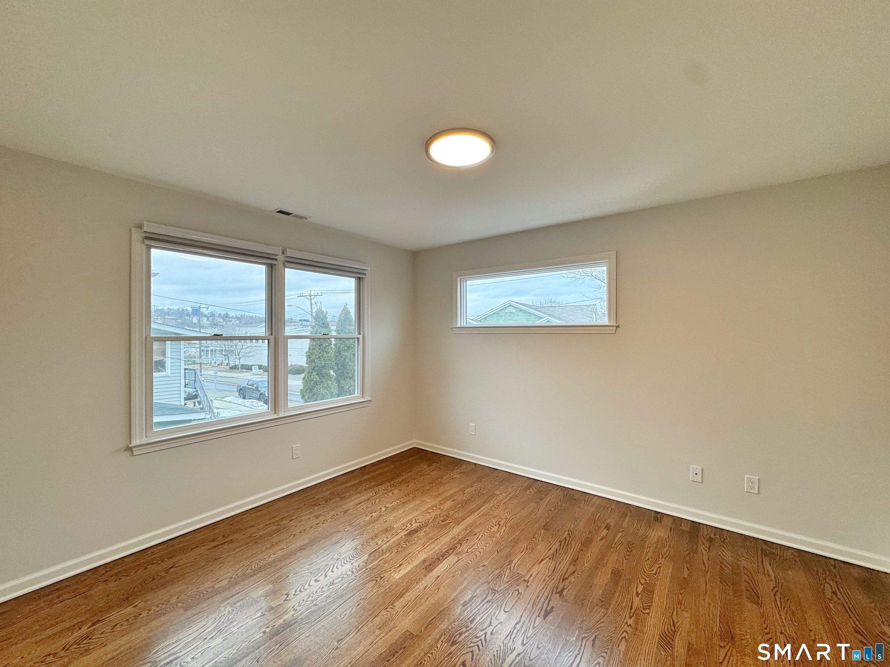 36 Chapel Street, Unit 1 Norwalk, CT 06850 - Photo 8 of 11 an empty room with wooden floor and windows