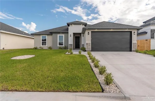 a front view of a house with a yard and garage