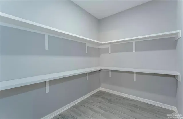 an empty room with wooden floor and closet