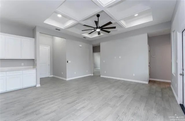 a view of an empty room with a window and a ceiling fan